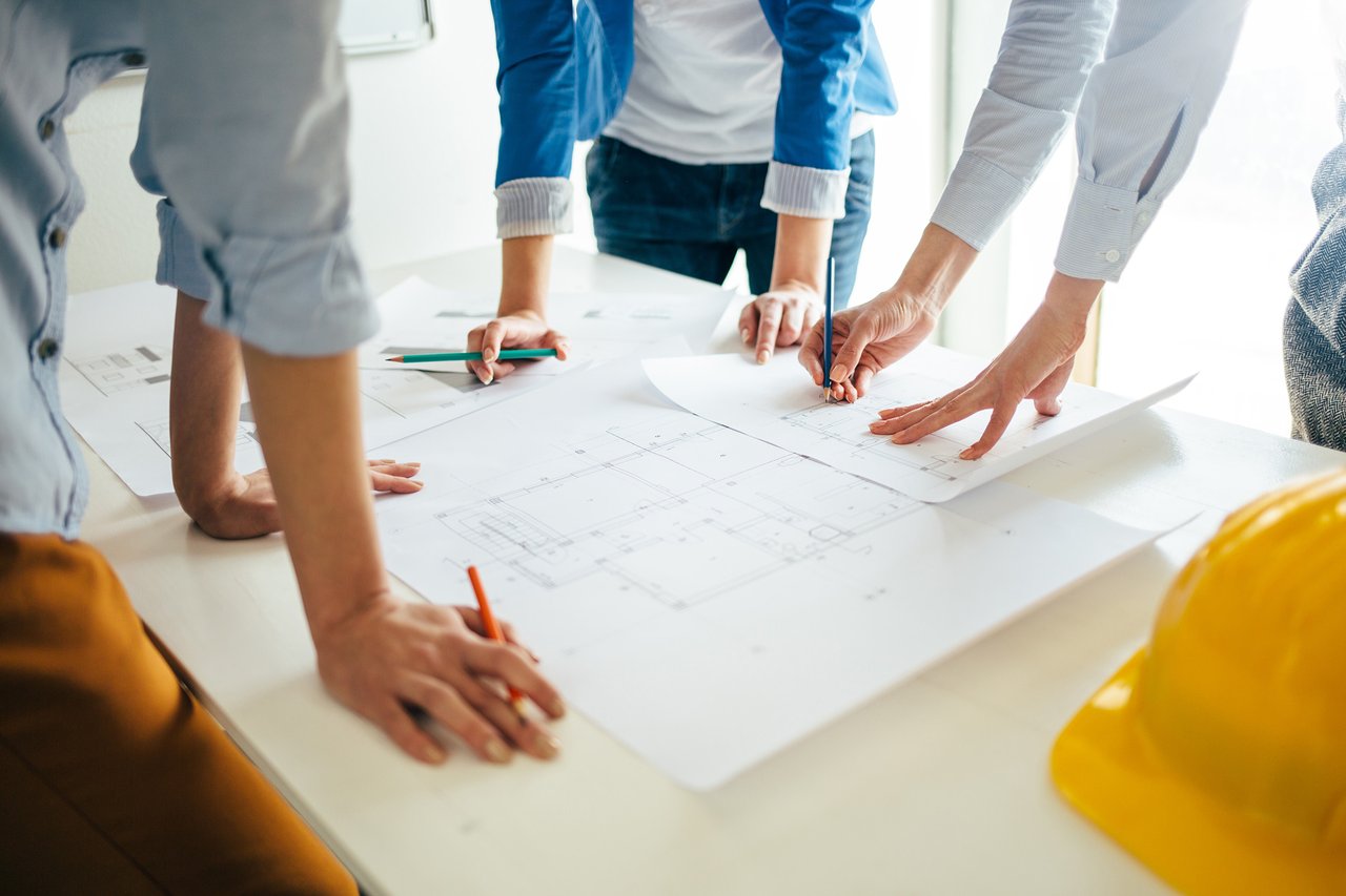 people standing around building plans